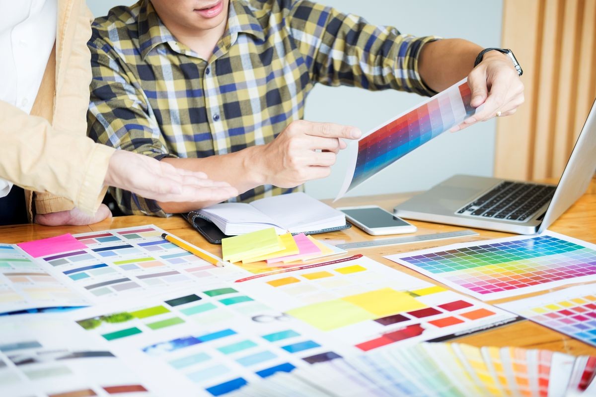 Professional Creative architect graphic desiner occupation choosing the Color pantone  palette samples for project on office desktop computer